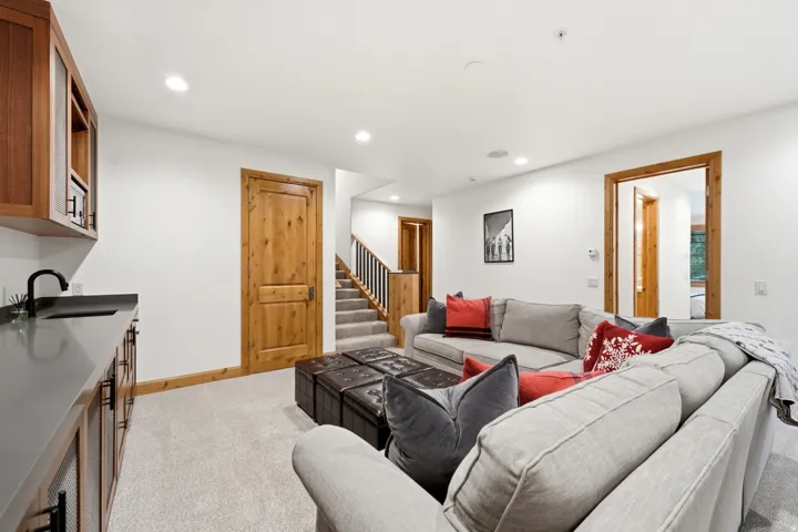 Lower-level living area featuring a built-in wet bar with dark countertops and wood cabinetry