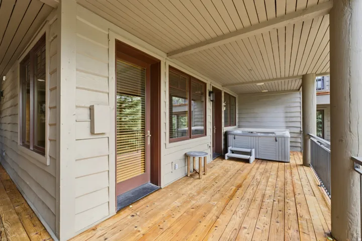 Spacious outdoor deck featuring natural wood flooring and a built-in hot tub