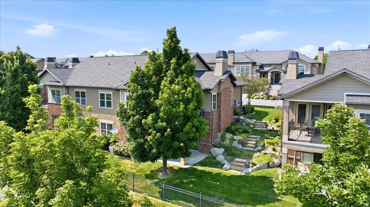 Exterior featuring multi-level landscaping with stone steps and mature trees