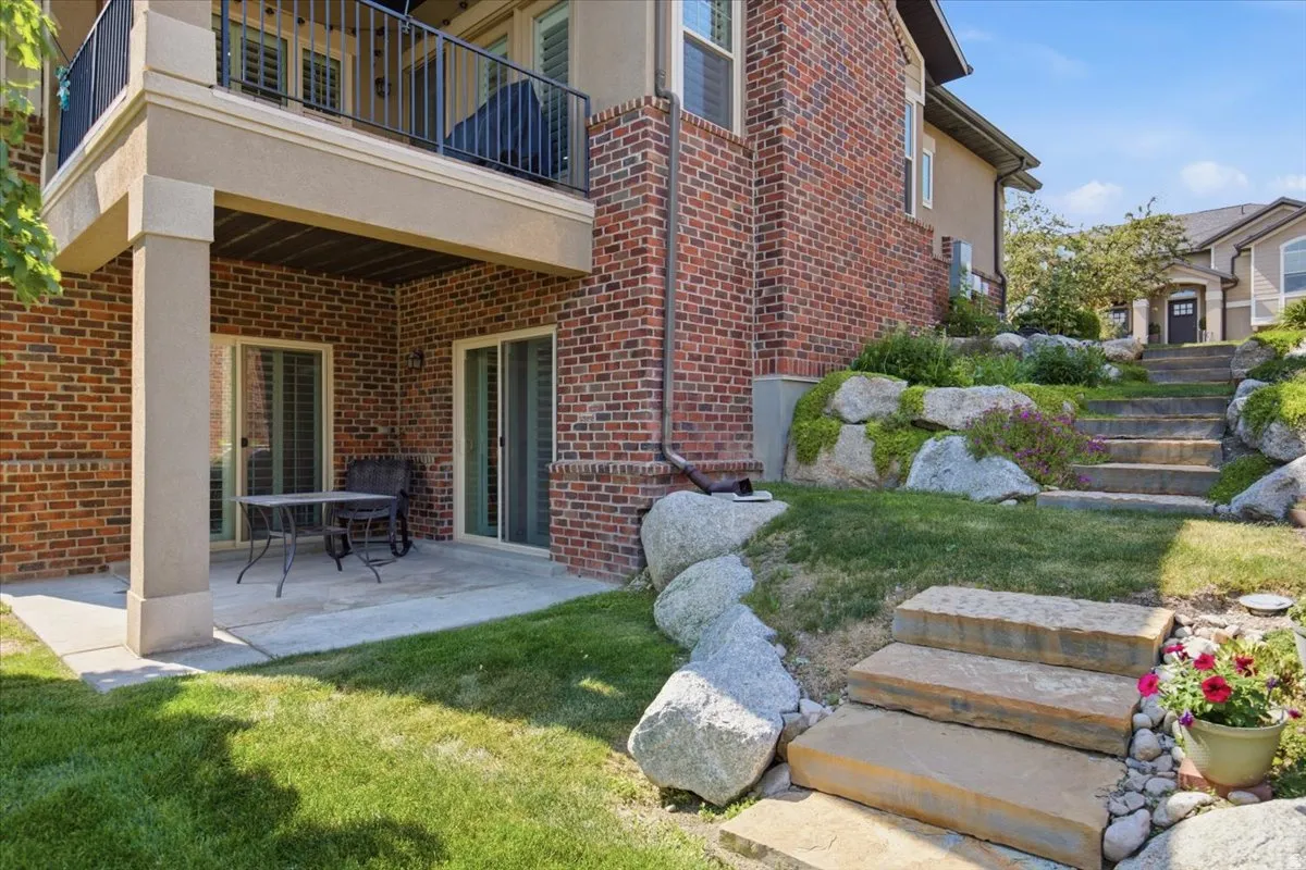 Lower-level patio area featuring concrete flooring and a brick-clad exterior