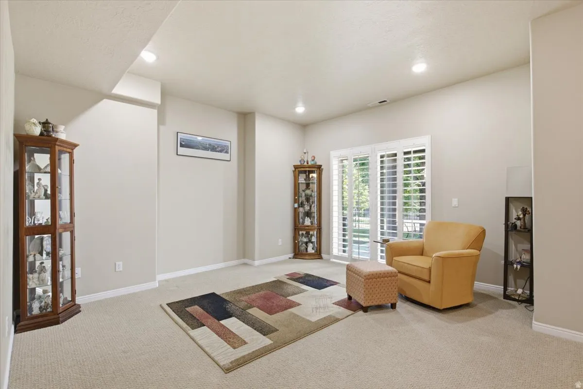 Carpeted interior space featuring recessed lighting, light-toned walls, and white baseboards