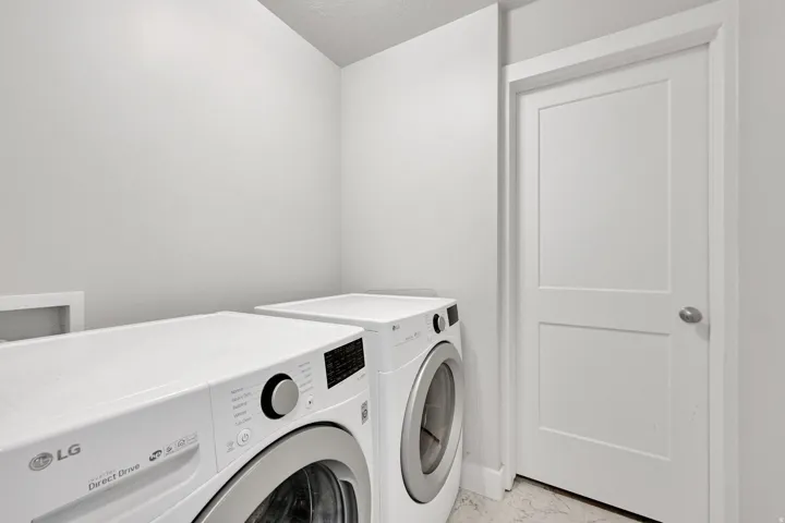 Dedicated laundry area featuring a front-loading washing machine and dryer