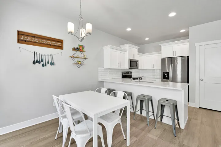 Bright kitchen featuring white cabinetry, stainless steel appliances, and a subway tile backsplash