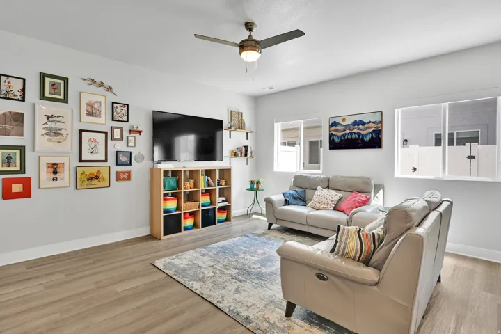 Spacious room featuring wood-finish flooring, white baseboards, and light-colored walls