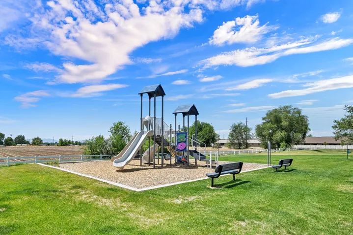 Outdoor playground featuring a slide, climbing elements, and protective ground covering