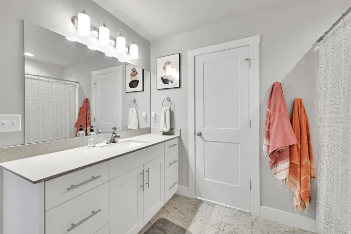 Spacious bathroom featuring an extended vanity with white cabinetry and a light-toned countertop