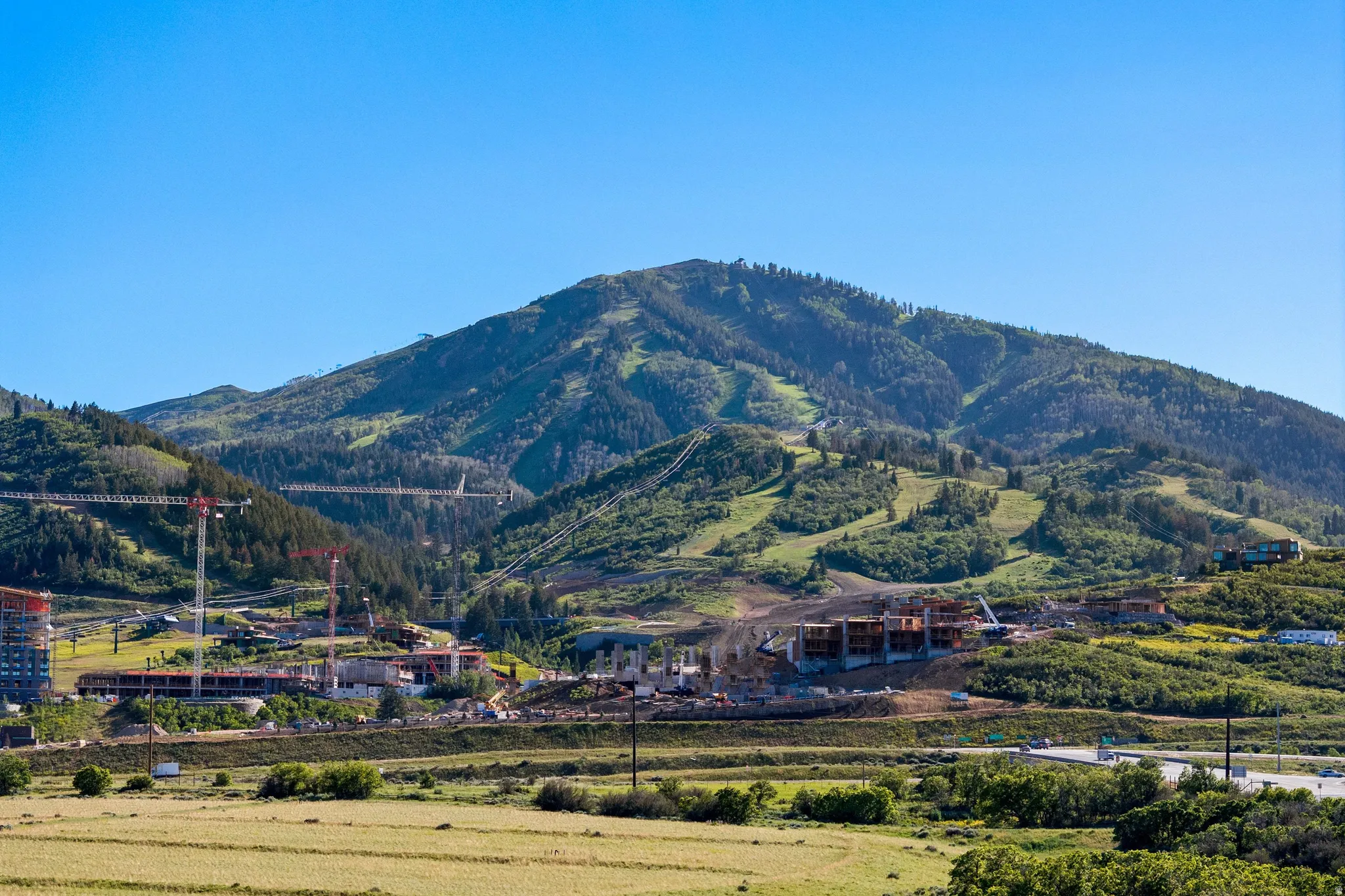 Expansive mountain terrain with visible ski slopes and verdant forests