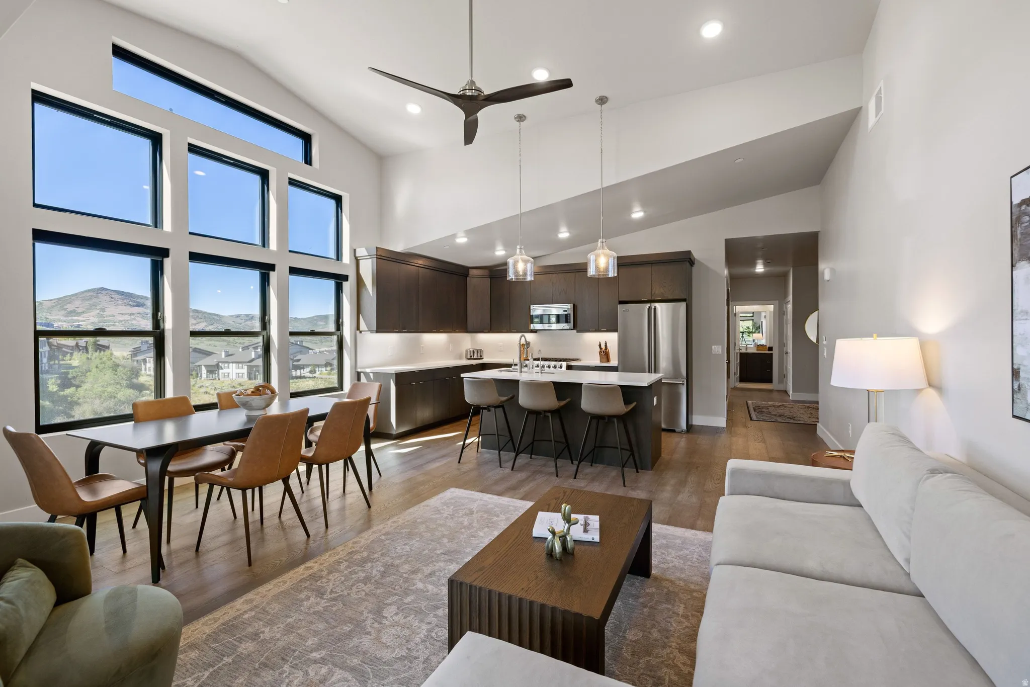 Open-concept living area with vaulted ceilings and large window array