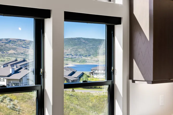 Framed mountain and lake scenery through multiple large windows with black sills