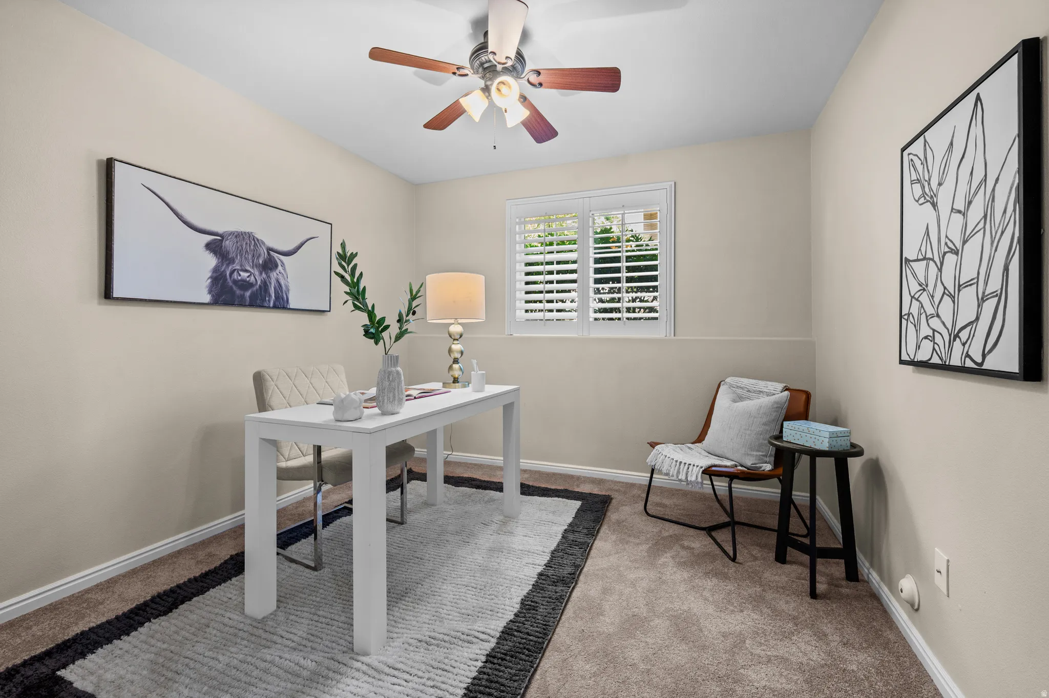 Neutral-toned room featuring a window with white plantation shutters, a ceiling fan with integrated lighting, and neutral carpeting