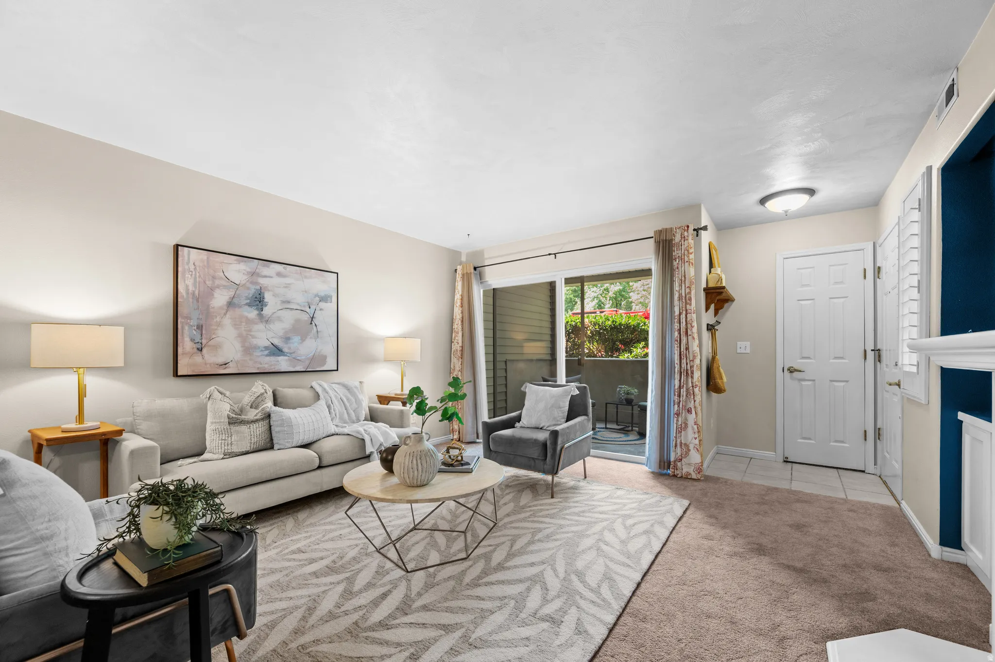 Living area featuring a sliding glass door to an outdoor patio, neutral wall tones, and varied flooring