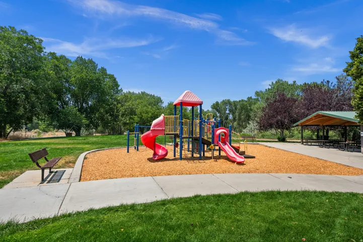 Community park featuring a vibrant playground with slides and climbing structures set on wood chip surfacing