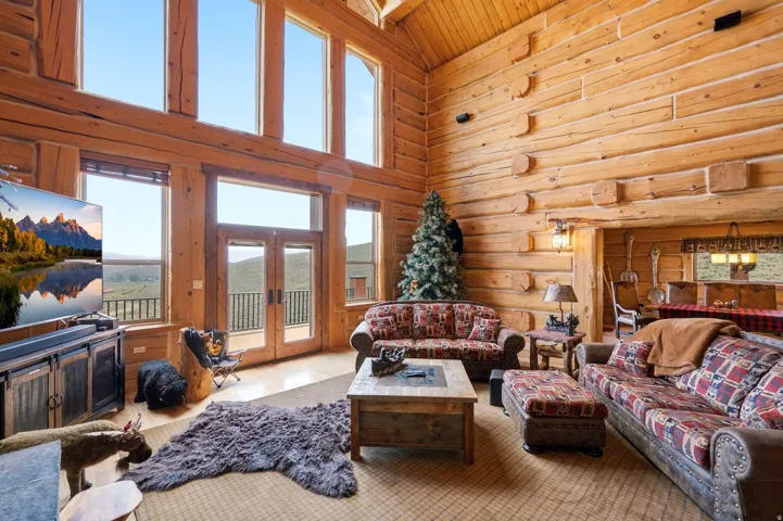 Expansive living area featuring soaring ceilings and exposed log construction