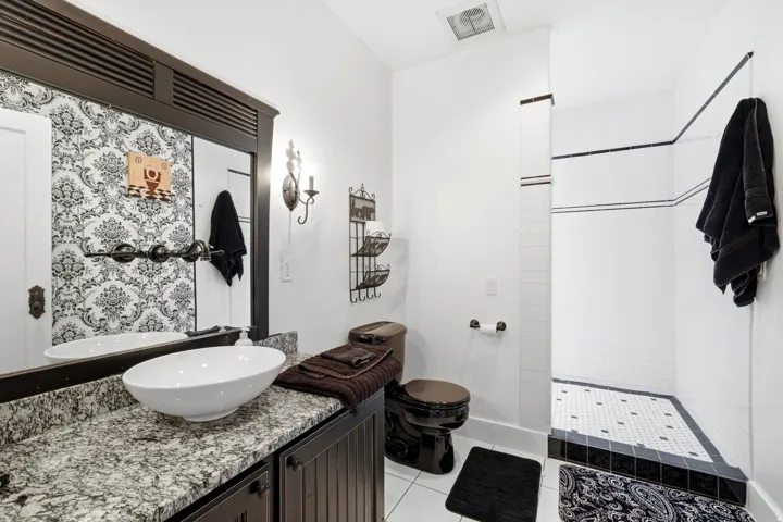 Bathroom featuring a dark wood-finish vanity with a granite countertop and vessel sink