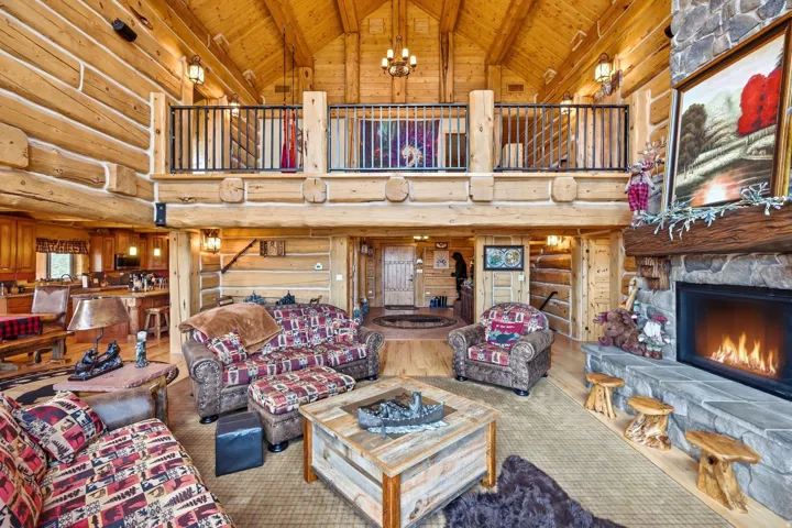Two-story living area with exposed log walls and vaulted ceilings