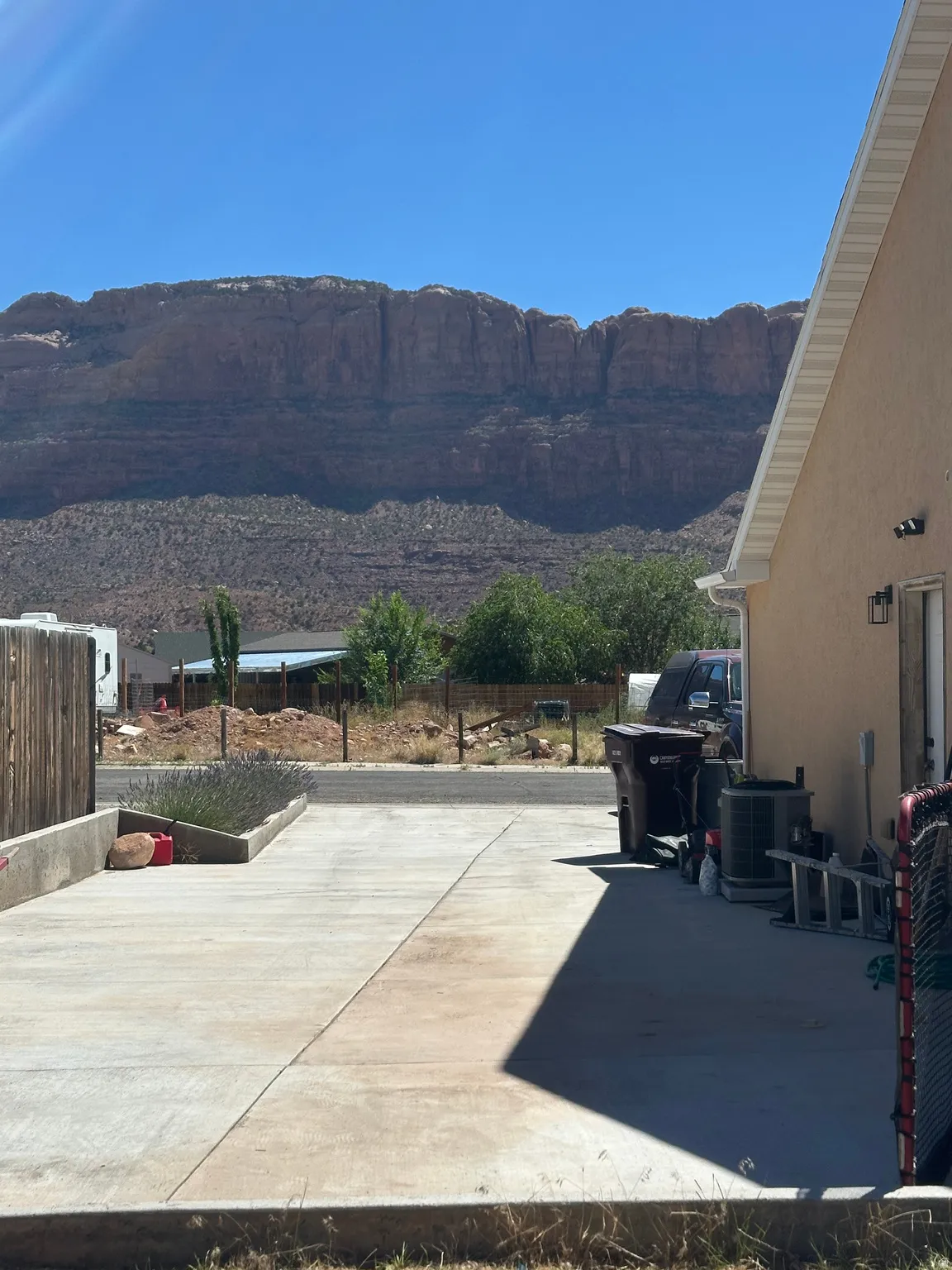 Concrete driveway with raised planting bed and a backdrop of expansive rock formations