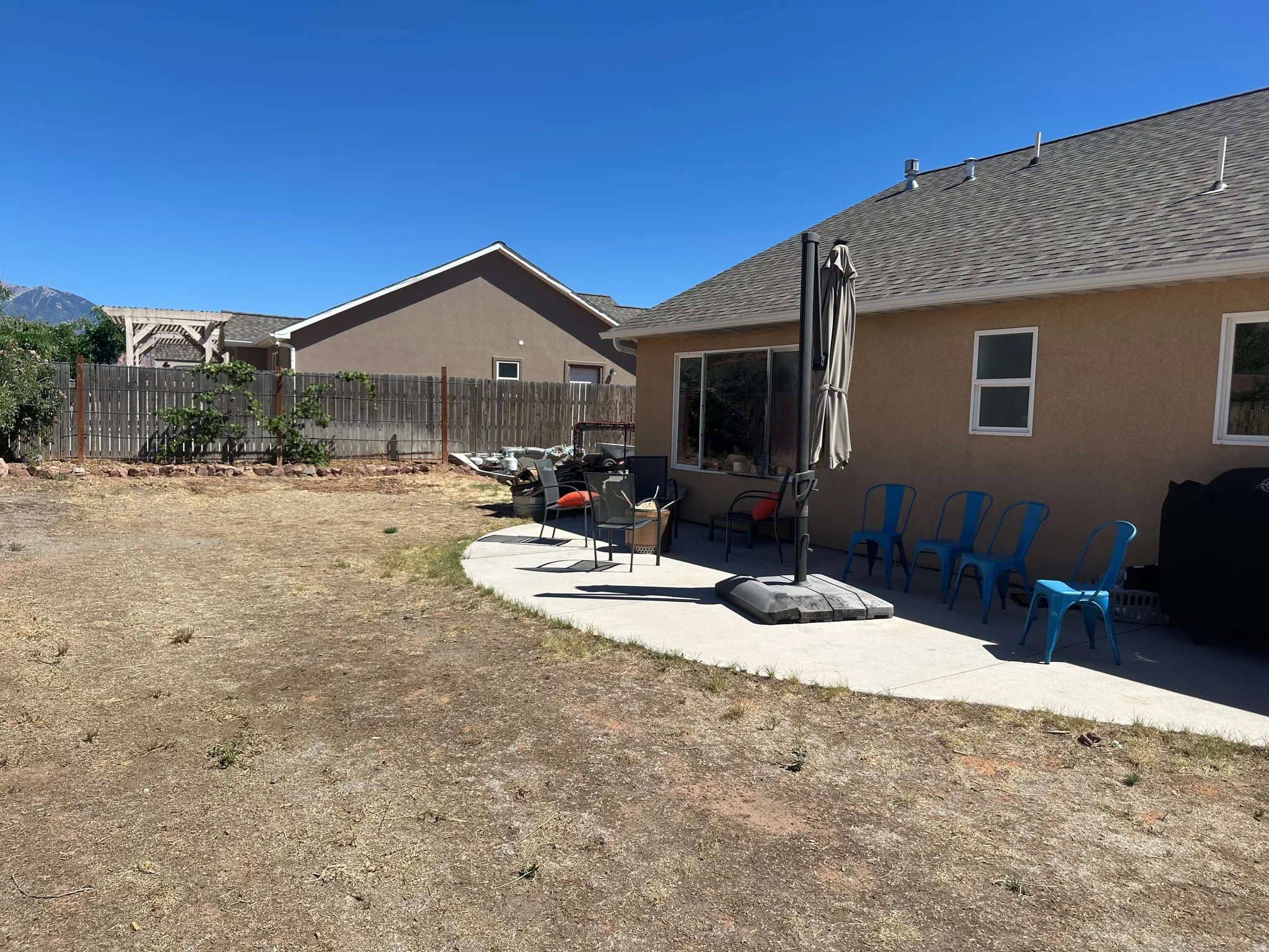 Rear exterior featuring a concrete patio, stucco siding, and a shingle roof