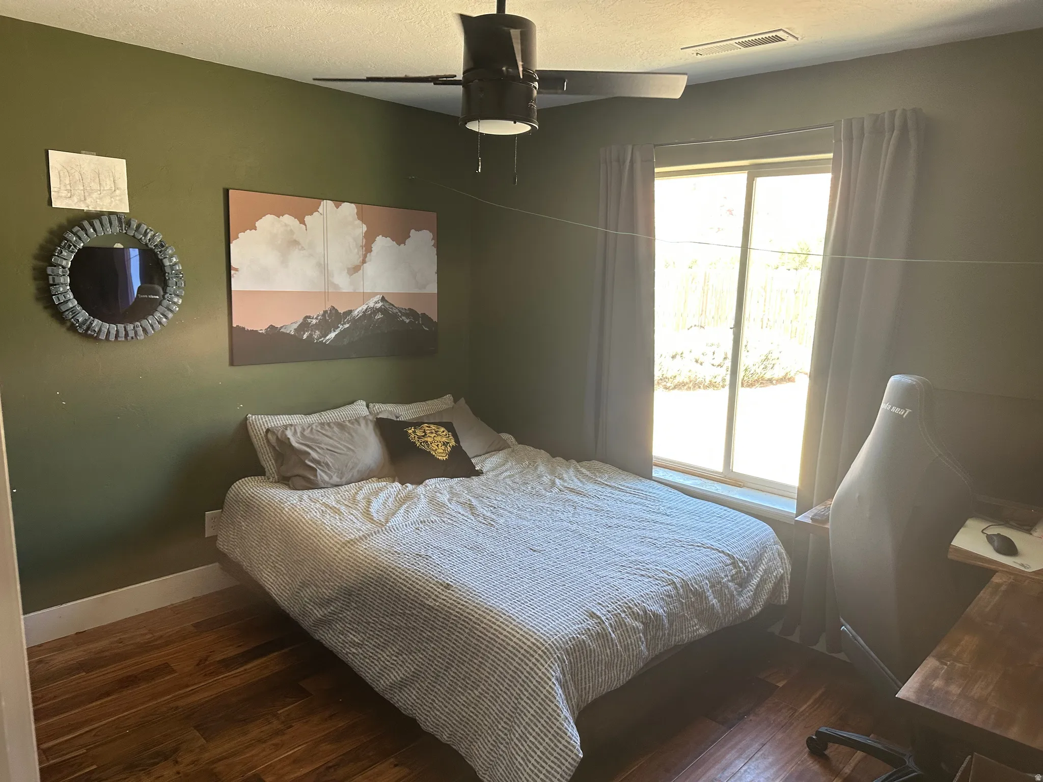 2nd bedroom featuring wood-finish flooring, a ceiling fan, and a large window with drapes