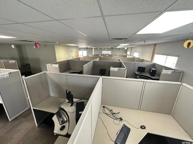 Open office area featuring multiple cubicle workstations with integrated desks