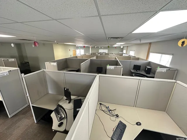 Spacious commercial interior featuring numerous cubicle workstations with integrated desks and privacy panels