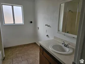 Bathroom featuring a white vanity with an integrated sink, chrome faucet, and a wall-mounted mirrored medicine cabinet