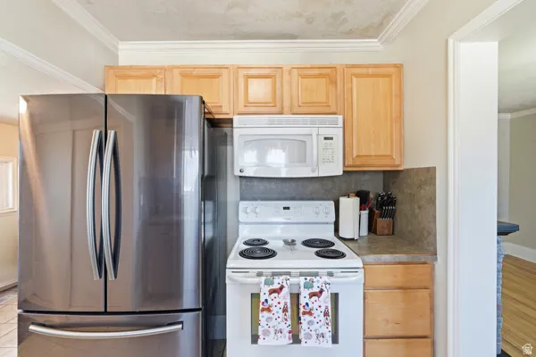 Kitchen workspace featuring a stainless steel French door refrigerator, white electric range, and a built-in microwave
