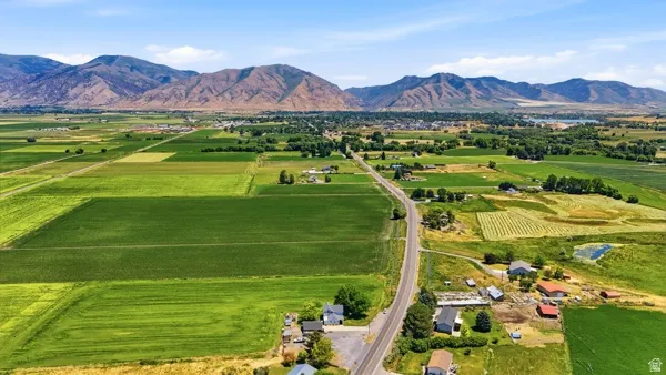 Expansive agricultural land featuring cultivated fields with distant mountainous terrain