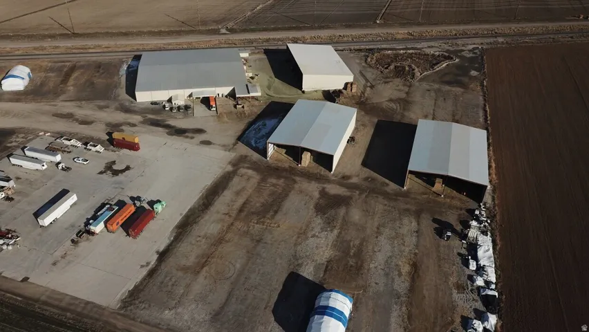 Expansive industrial property featuring multiple large metal buildings, a substantial paved lot, and direct rail access