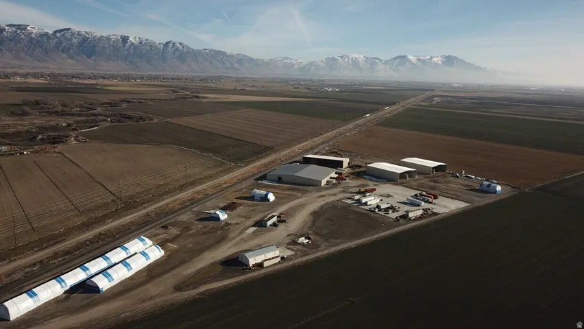 Expansive agricultural property featuring multiple large industrial buildings, a paved lot, and substantial land parcels