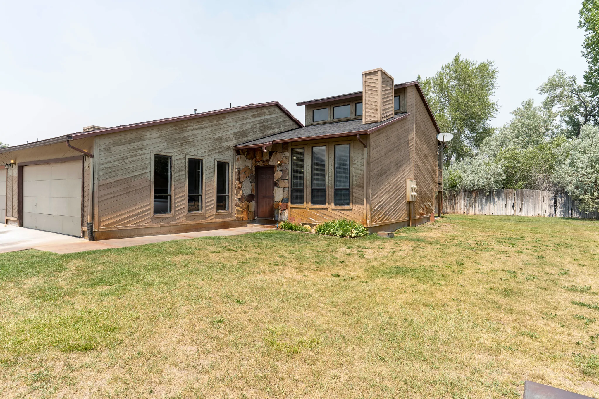 Multi-level exterior featuring wood paneling and stone accents