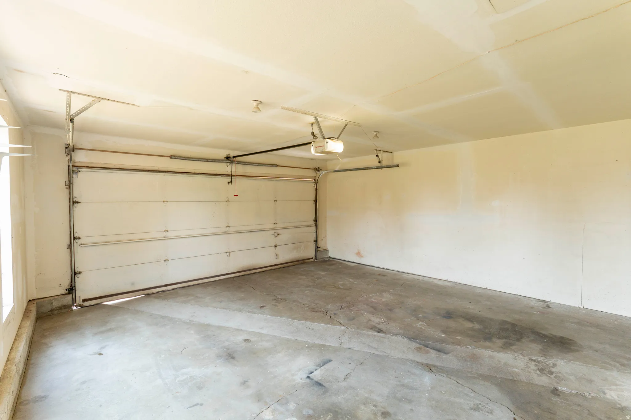 Spacious garage with a sectional overhead door and an automatic opener system