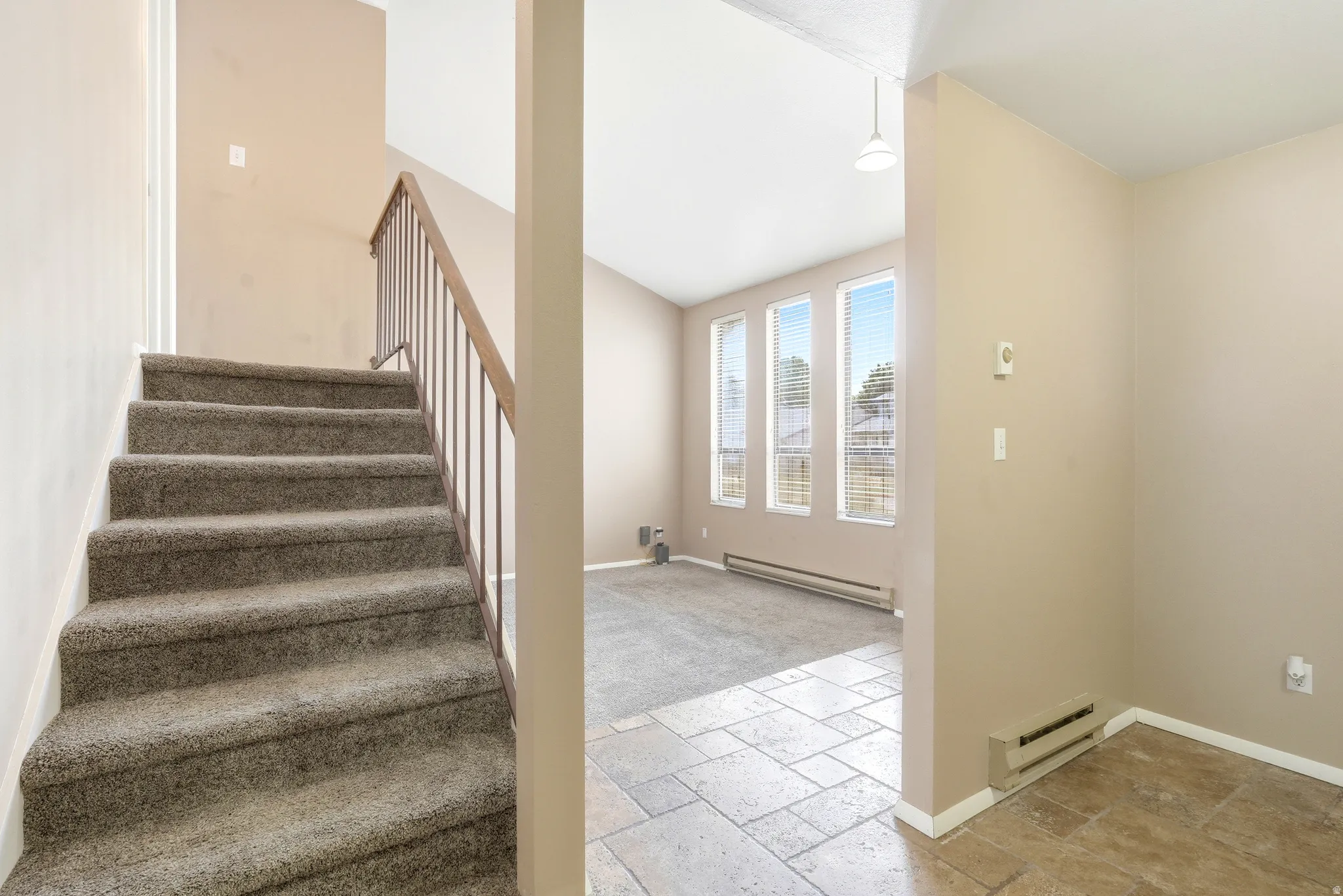 Carpeted staircase with metal and wood-finish railing