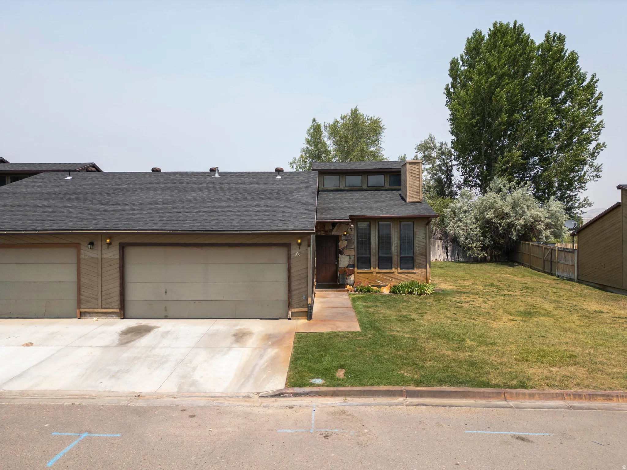 Wood-sided residence with a stone facade accent and a charcoal shingle roof