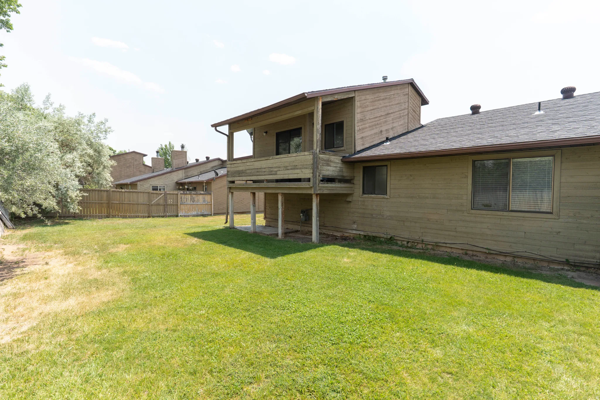 Rear exterior showcasing a raised wood deck, a pitched roof, and horizontal siding