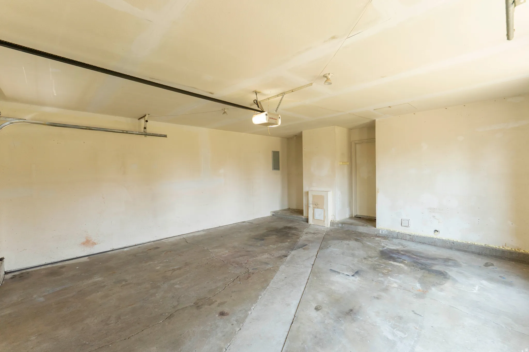 Spacious interior garage featuring a concrete floor and neutral-toned walls
