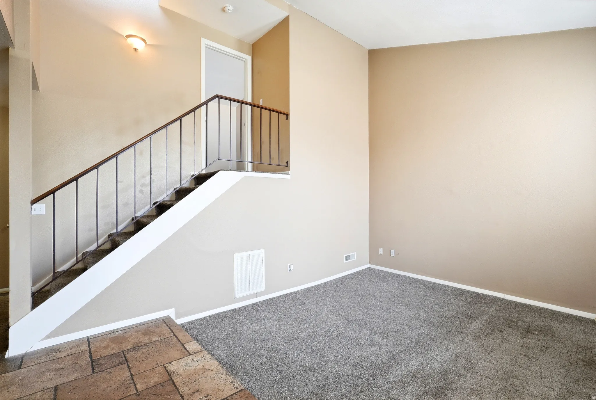 Entryway with tile flooring opening to a carpeted living space