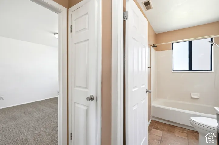 Bathroom featuring a white tub, shower fixture, and a window with dark framing