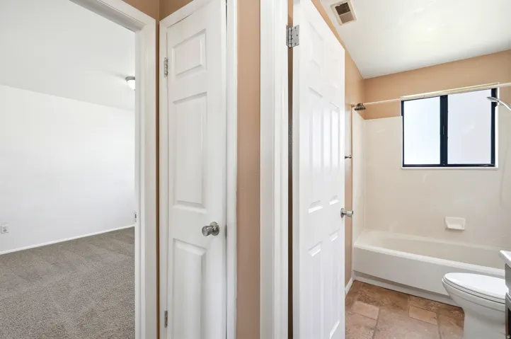 Bathroom featuring a white tub, shower fixture, and a window with dark framing