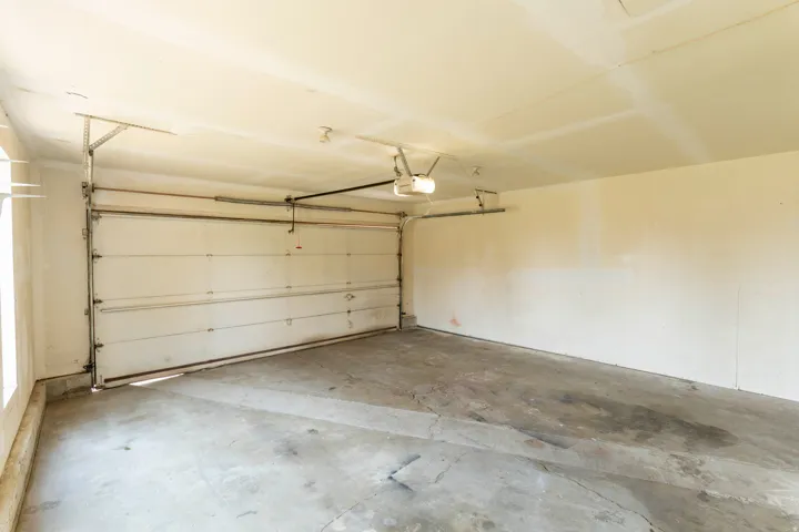 Spacious garage with a sectional overhead door and an automatic opener system