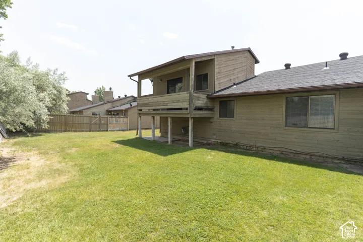 Rear exterior showcasing a raised wood deck, a pitched roof, and horizontal siding