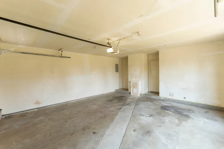 Spacious interior garage featuring a concrete floor and neutral-toned walls