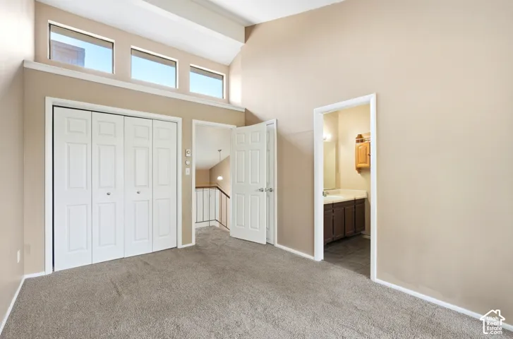 Primary bedroom with vaulted ceilings with exposed beams and upper transom windows