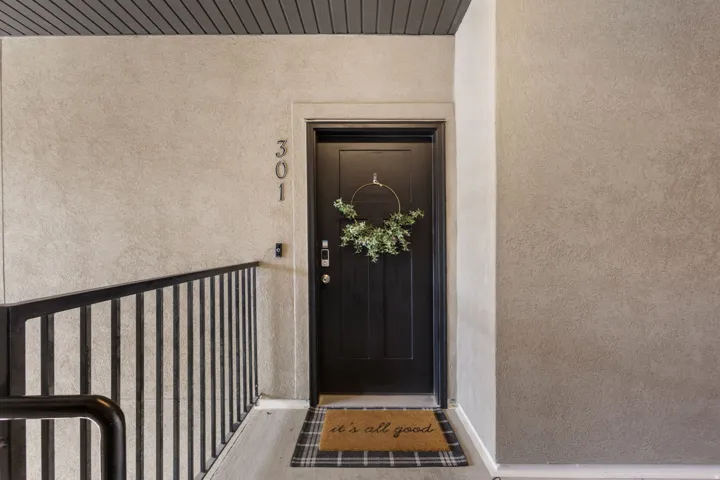 Entryway featuring a dark paneled door with modern hardware, textured wall finish, and dark slat ceiling