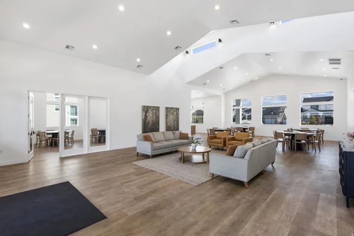 Spacious common area featuring wood-finish flooring, vaulted ceilings, and recessed lighting