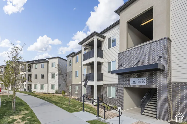 Modern multi-story building featuring varied facade materials including horizontal siding and brick-style cladding