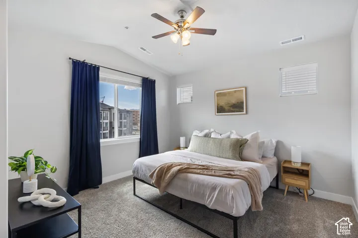 Bedroom featuring a vaulted ceiling and a ceiling fan with integrated lighting