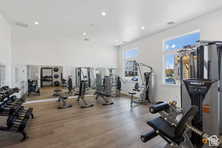 Fitness center featuring wood-finish flooring, recessed lighting, and multiple windows