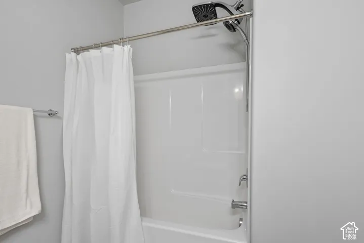 Tub and shower combination featuring a white surround, chrome fixtures, and a multi-function shower head