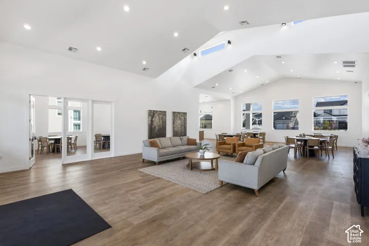 Spacious common area featuring wood-finish flooring, vaulted ceilings, and recessed lighting