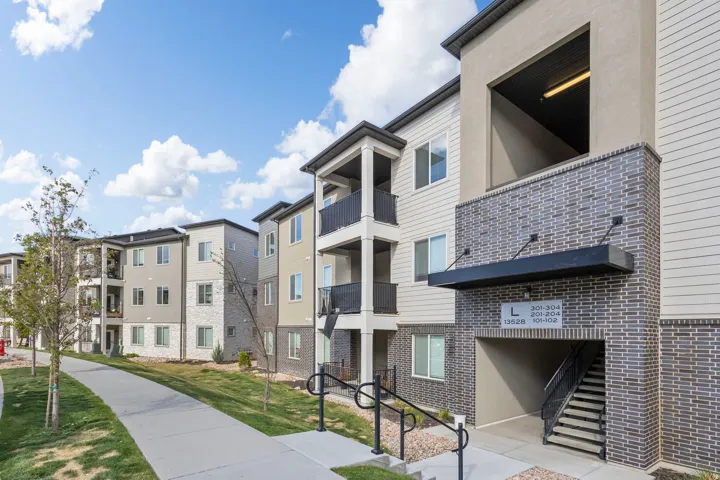 Modern multi-story building featuring varied facade materials including horizontal siding and brick-style cladding